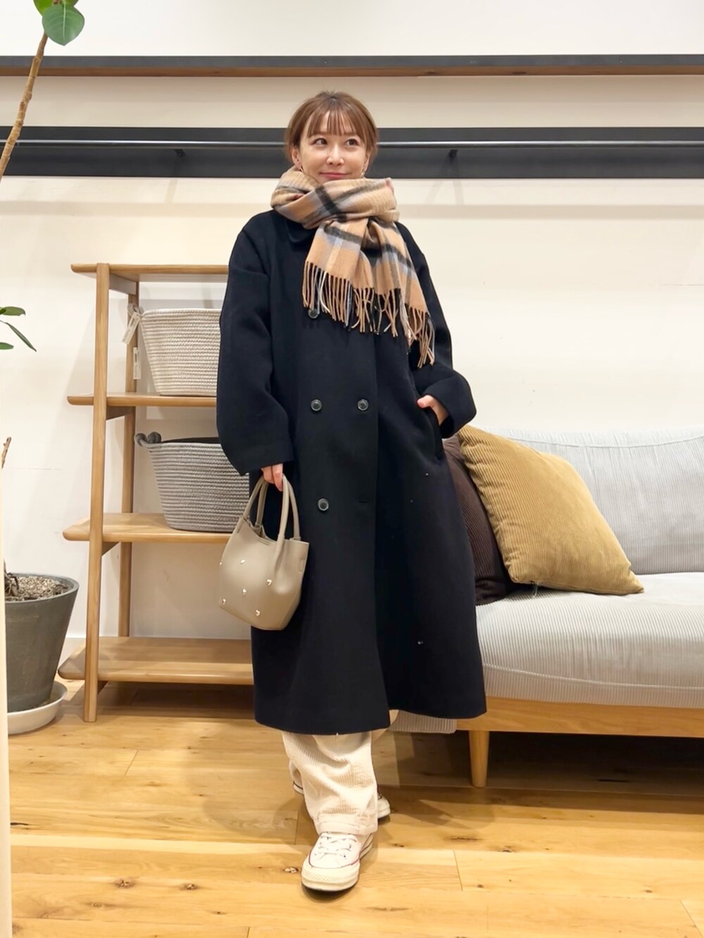 レッド系のニット/セーター、ブラック系のショルダーバッグ、ホワイト系のその他パンツを着用したレディースの冬コーディネートの6枚目の写真