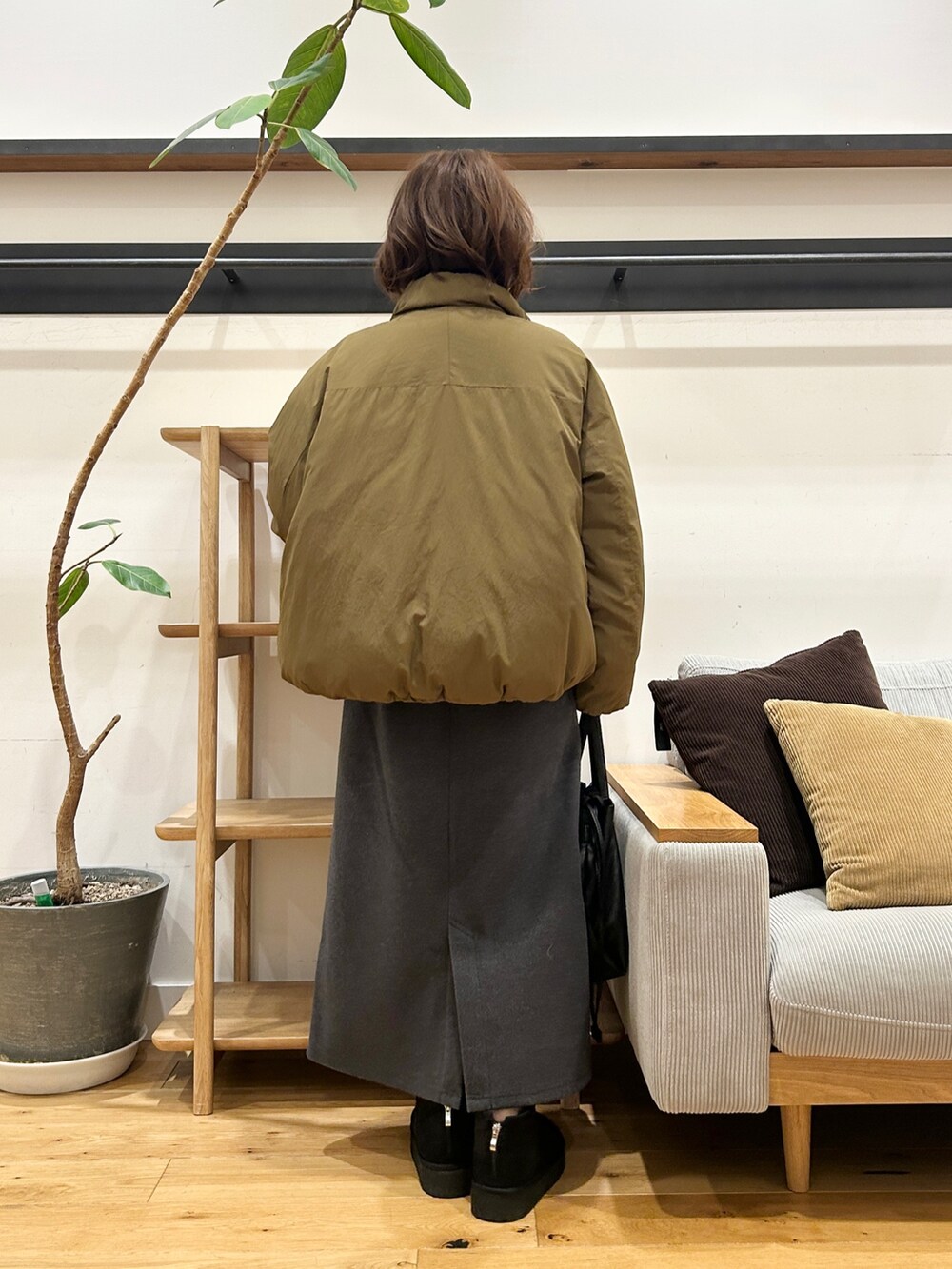 グリーン系のブルゾン、グレー系のカーディガン/ボレロ、グレー系のスカートを着用したレディースの冬コーディネートの6枚目の写真