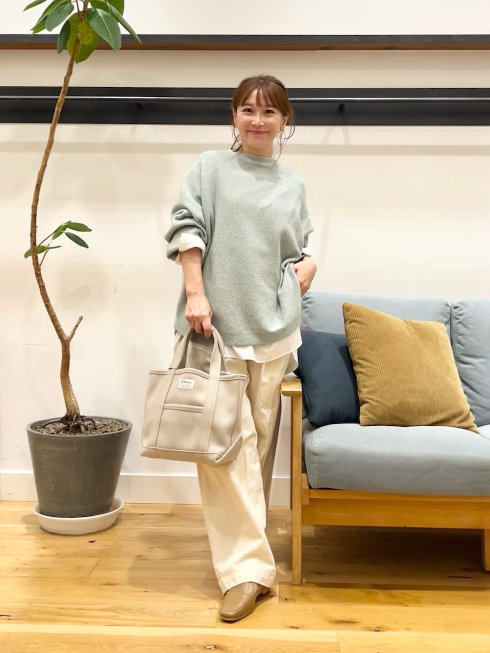 ピンク系のニット/セーター、ベージュ系のデニムパンツを着用したレディースの秋コーディネートの2枚目の写真