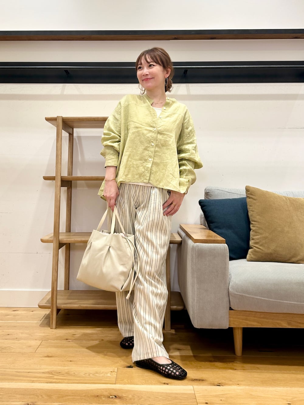 イエロー系のシャツ/ブラウス、ベージュ系のその他パンツ、ホワイト系のショルダーバッグを着用したレディースの春コーディネートの5枚目の写真