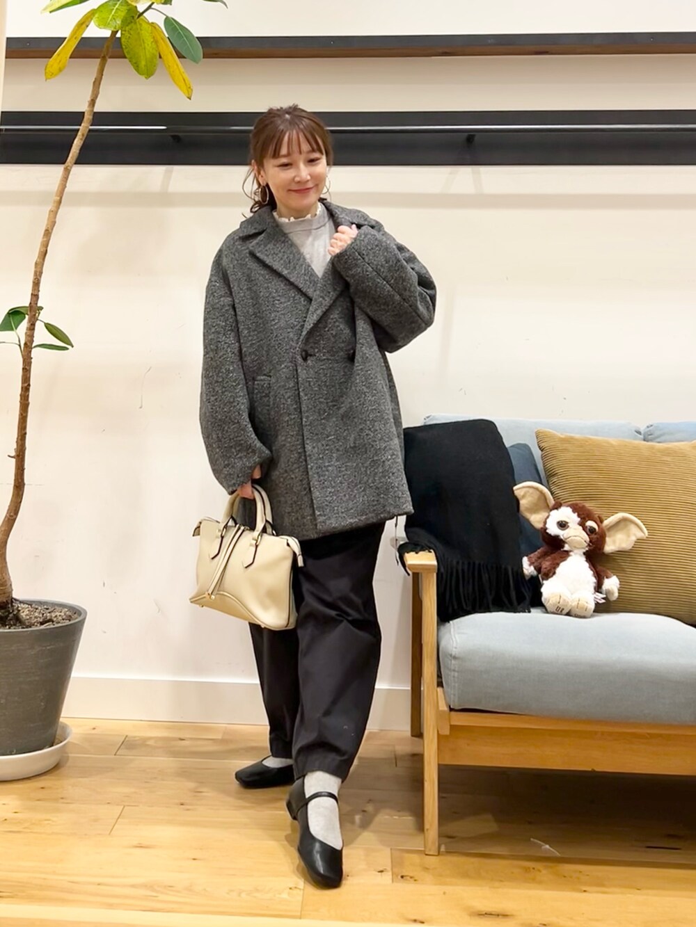 ブルー系のニット/セーター、ホワイト系のシャツ/ブラウス、グレー系のその他アウターを着用したレディースの冬コーディネートの2枚目の写真