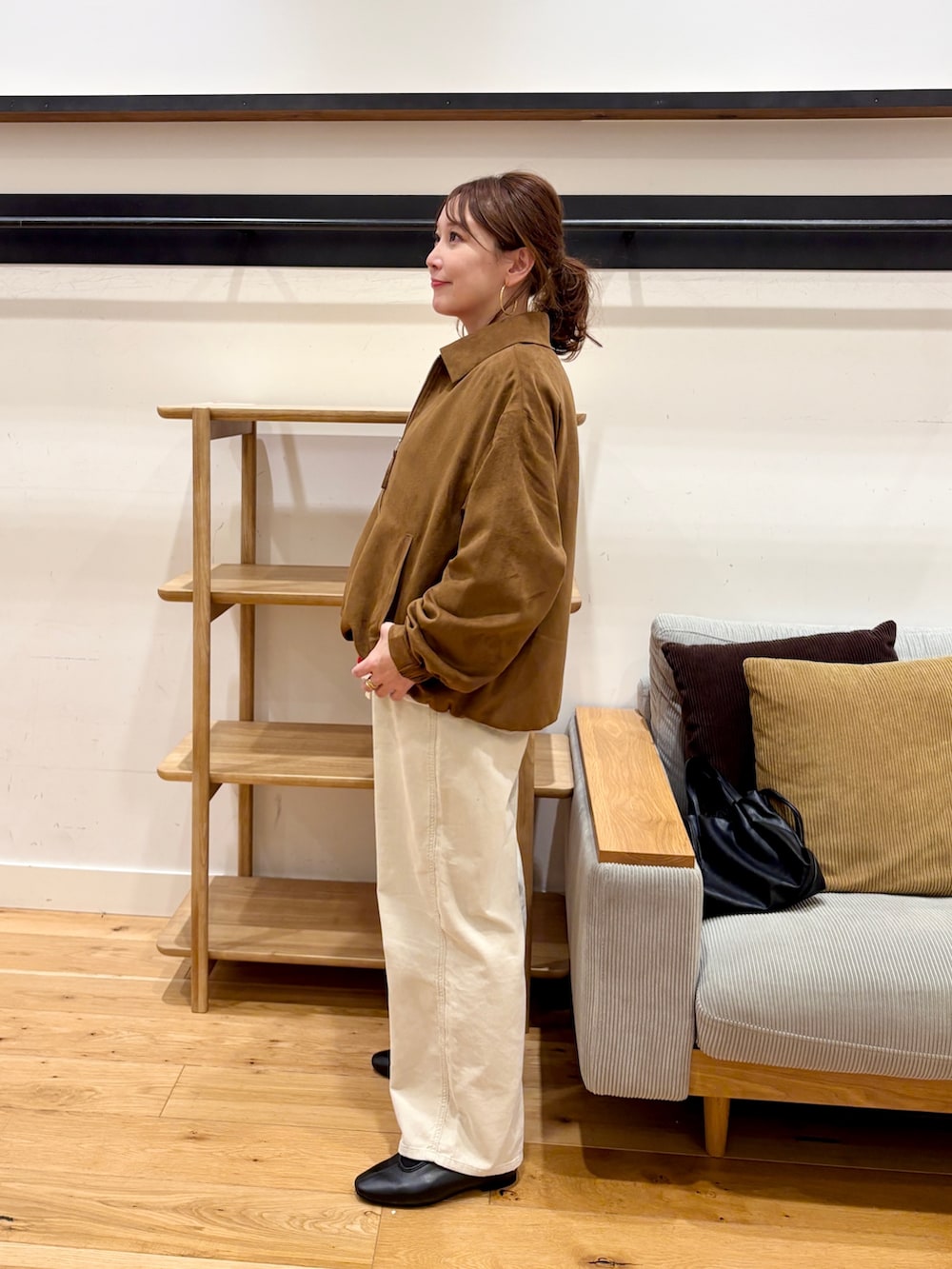 イエロー系のブルゾン、レッド系のニット/セーター、ホワイト系のその他パンツを着用したレディースの秋コーディネートの4枚目の写真