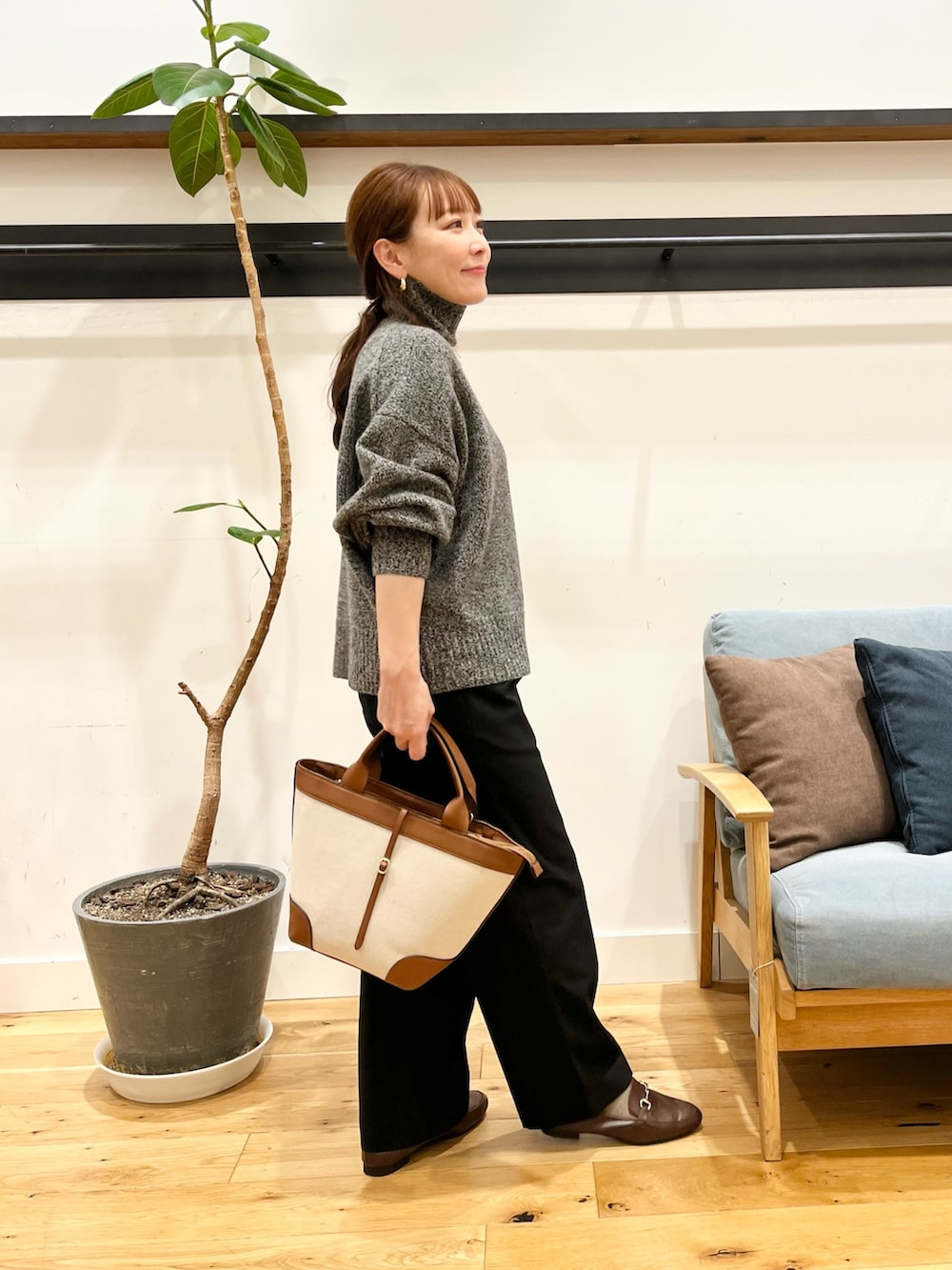 グレー系のニット/セーター、ブラック系のその他パンツ、ブラウン系のローファーを着用したレディースの冬コーディネートの2枚目の写真