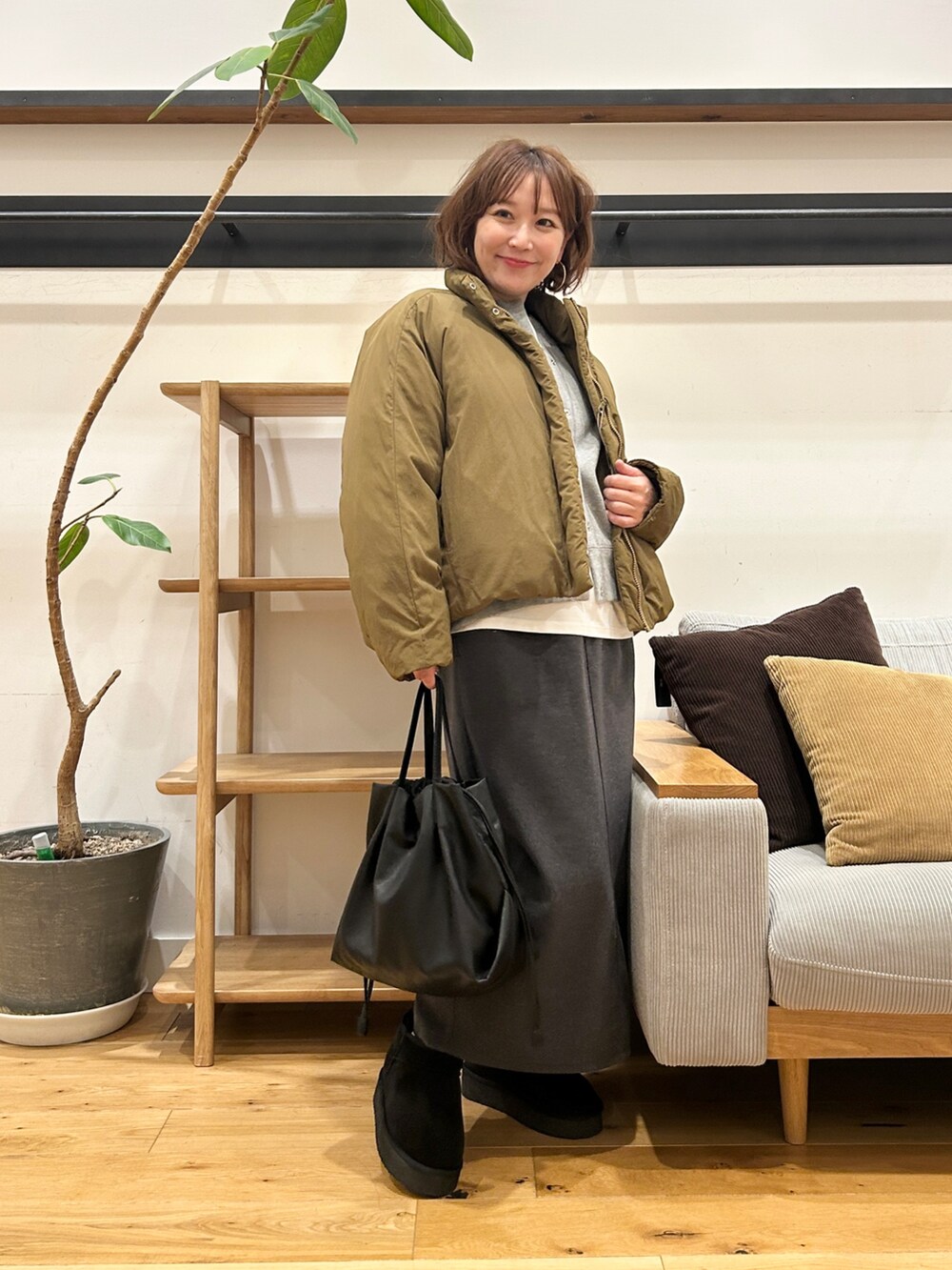 グリーン系のブルゾン、グレー系のカーディガン/ボレロ、グレー系のスカートを着用したレディースの冬コーディネートの7枚目の写真