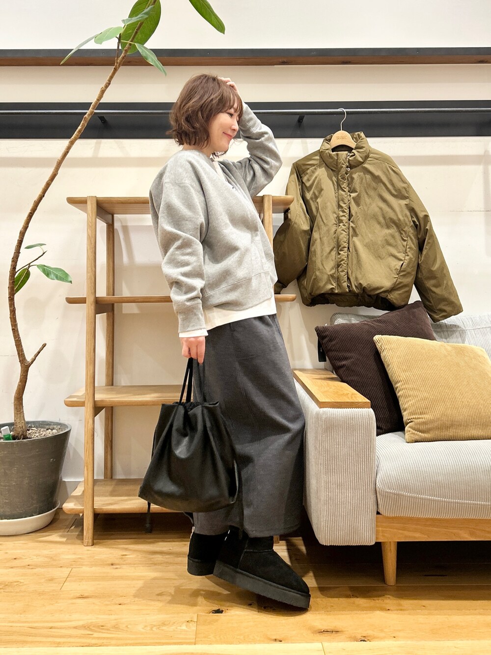 グリーン系のブルゾン、グレー系のカーディガン/ボレロ、グレー系のスカートを着用したレディースの冬コーディネートの4枚目の写真