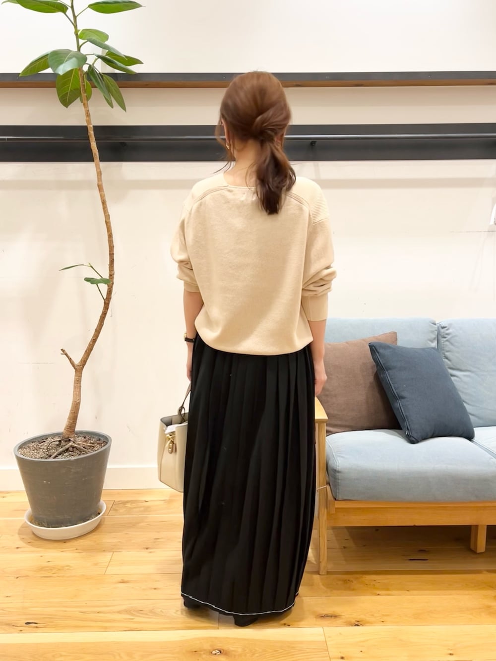 ホワイト系のニット/セーター、ブラック系のスカート、ホワイト系のトートバッグを着用したレディースの冬コーディネートの5枚目の写真