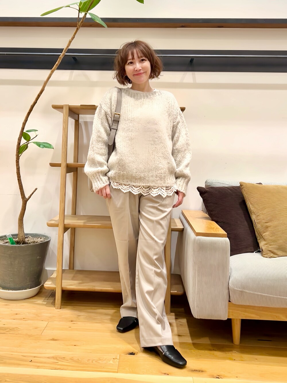 グレー系のニット/セーター、ホワイト系のTシャツ/カットソー、ベージュ系のその他パンツを着用したレディースの秋コーディネートの4枚目の写真