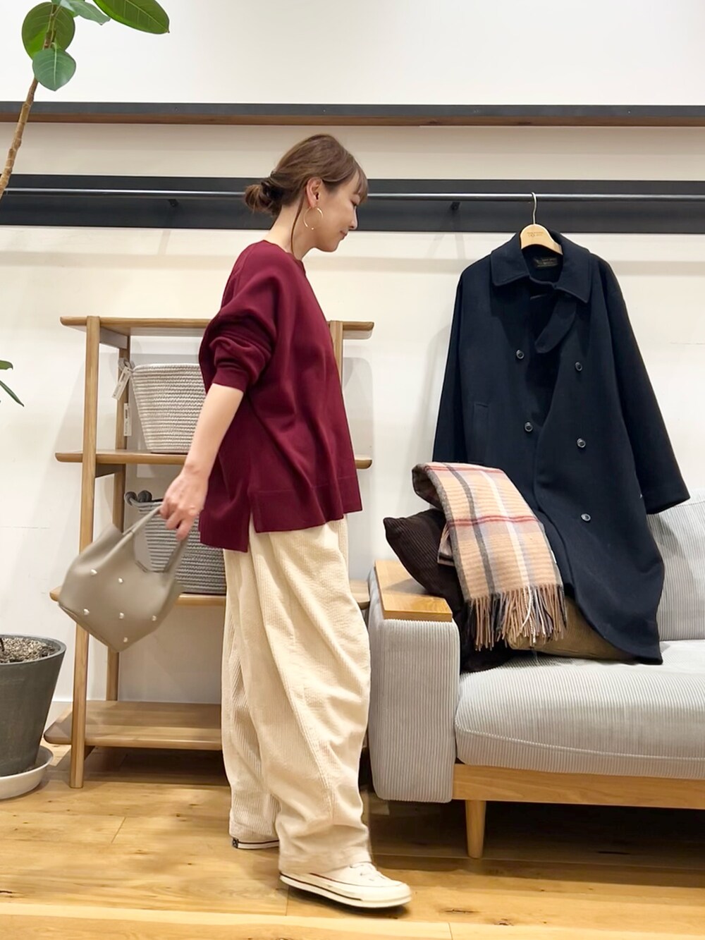 レッド系のニット/セーター、ブラック系のショルダーバッグ、ホワイト系のその他パンツを着用したレディースの冬コーディネートの4枚目の写真