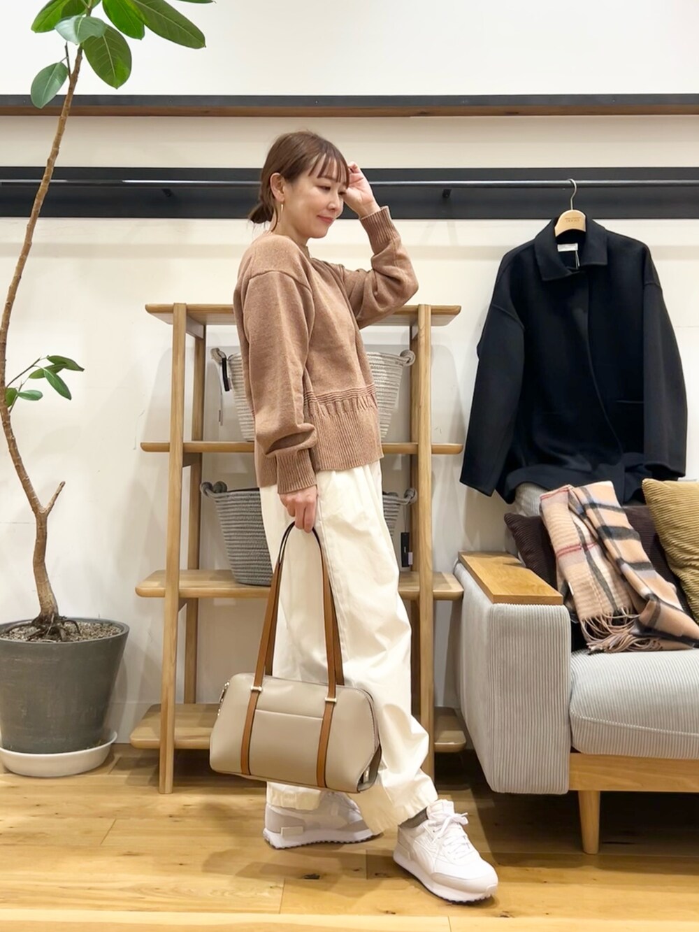 ベージュ系のニット/セーター、ホワイト系のその他パンツ、ブラック系のボストンバッグを着用したレディースの冬コーディネートの4枚目の写真