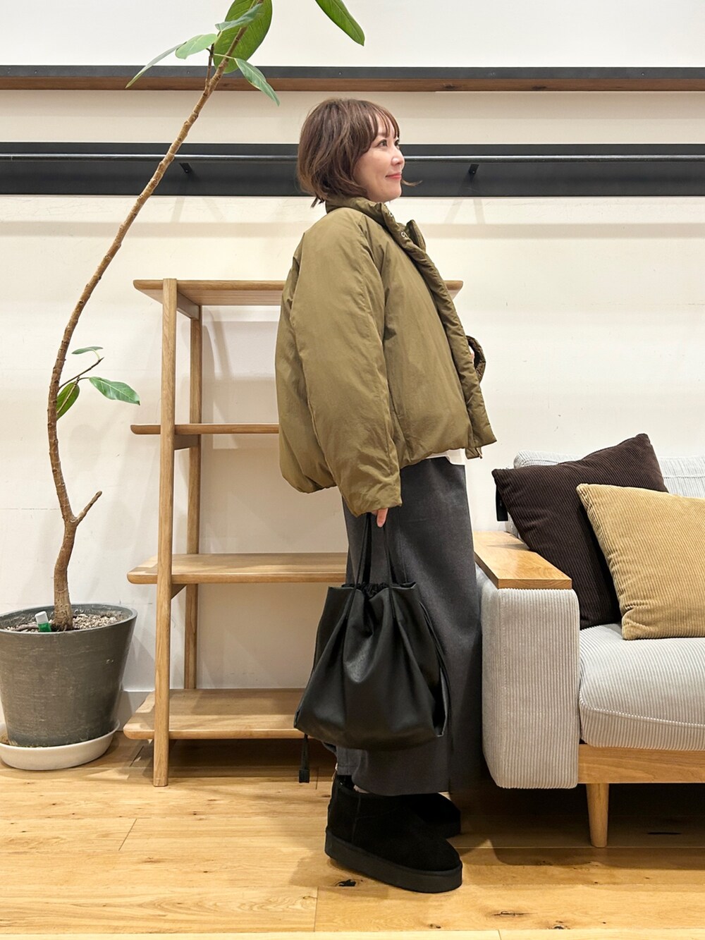 グリーン系のブルゾン、グレー系のカーディガン/ボレロ、グレー系のスカートを着用したレディースの冬コーディネートの5枚目の写真