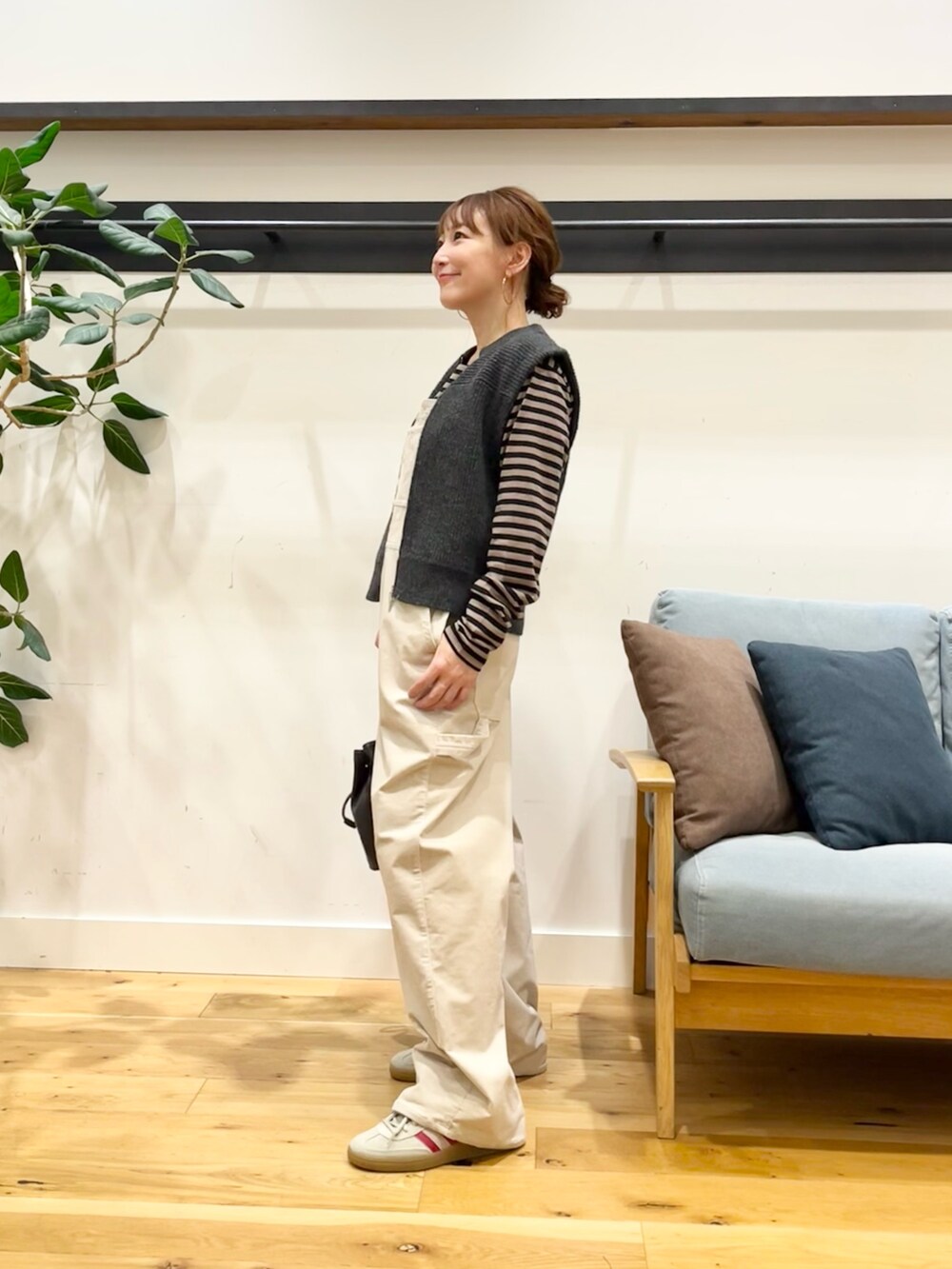 ホワイト系のサロペット/オーバーオール、グレー系のベスト、ベージュ系のTシャツ/カットソーを着用したレディースの秋コーディネートの2枚目の写真