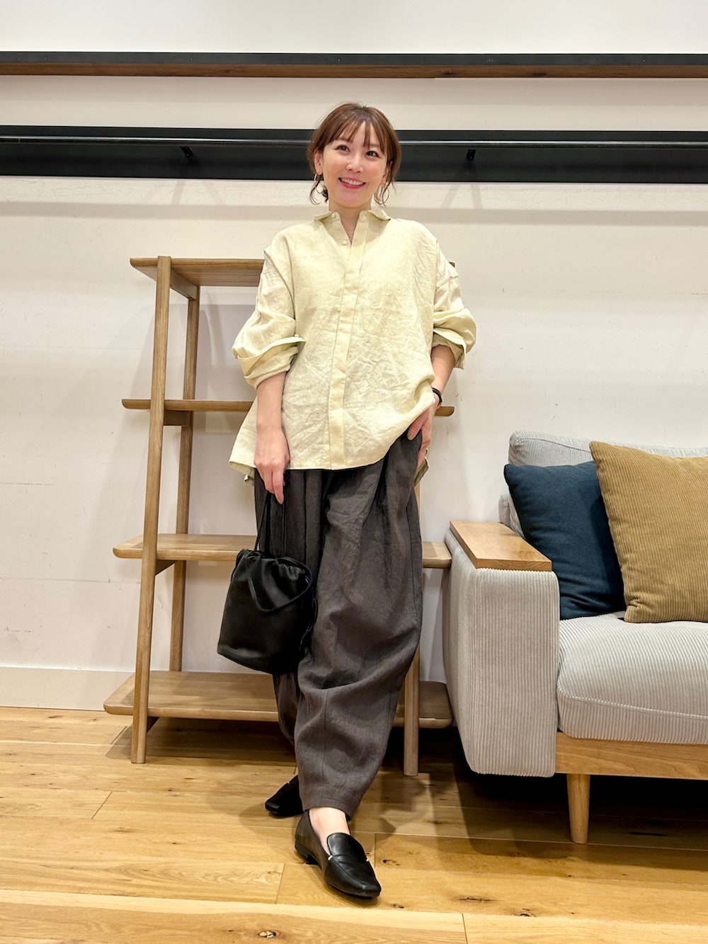 イエロー系のシャツ/ブラウス、グレー系のその他パンツ、ブラック系のショルダーバッグを着用したレディースの春コーディネートの5枚目の写真