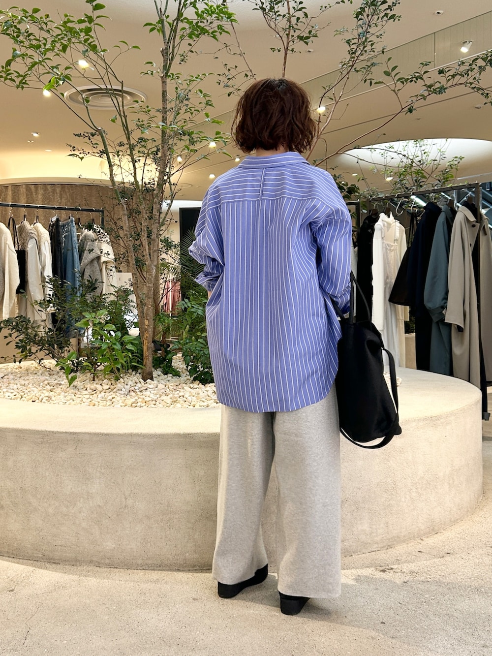 ブルー系のシャツ/ブラウス、ベージュ系のその他パンツ、ブラック系のトートバッグを着用したレディースの秋コーディネートの3枚目の写真