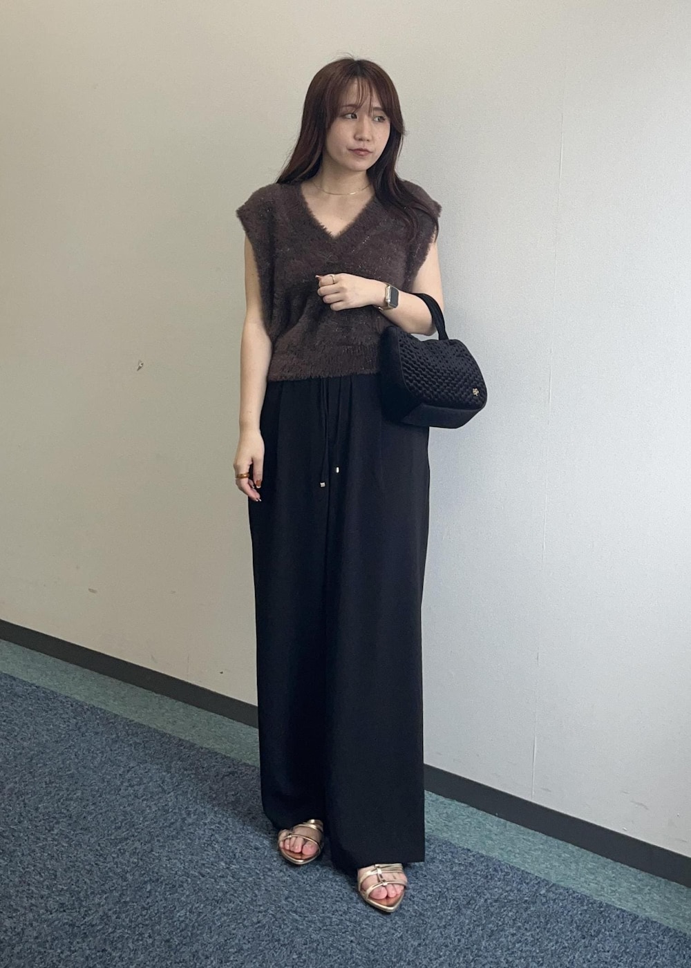 ブラウン系のベスト、ブラック系のその他パンツ、ブラック系のショルダーバッグを着用したレディースの夏コーディネートの2枚目の写真