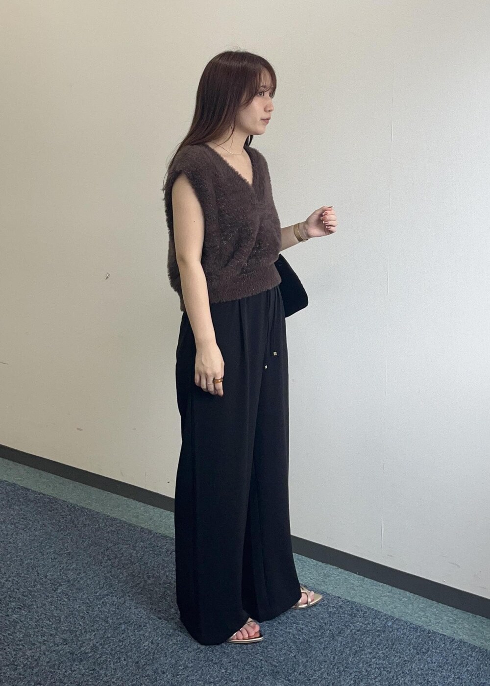 ブラウン系のベスト、ブラック系のその他パンツ、ブラック系のショルダーバッグを着用したレディースの夏コーディネートの5枚目の写真