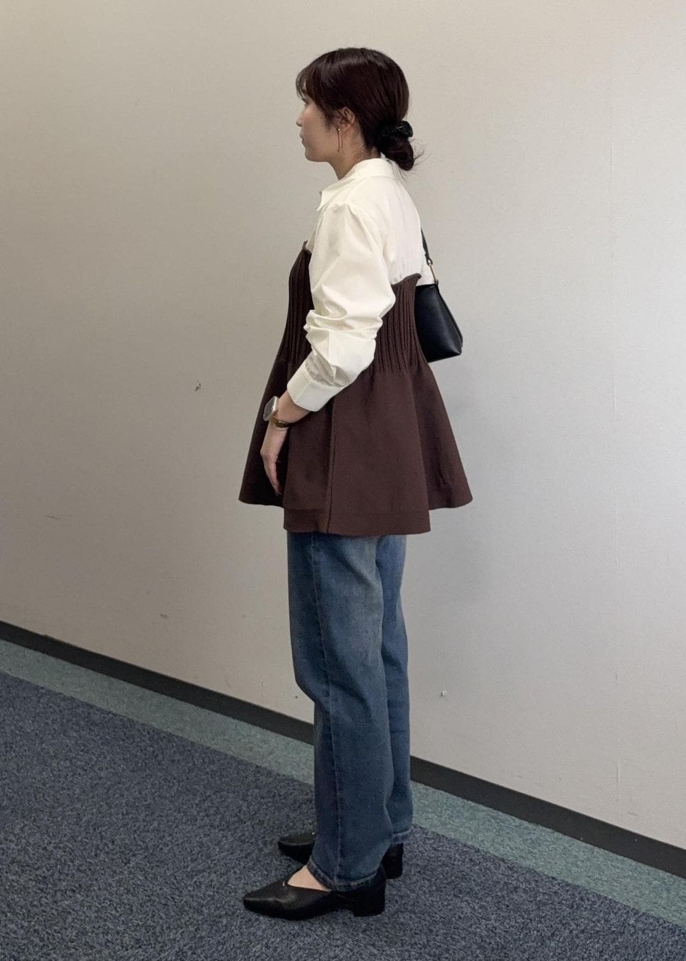 ブラック系のショルダーバッグ、ブラウン系のシャツ/ブラウス、ブルー系のデニムパンツを着用したレディースの春コーディネートの4枚目の写真