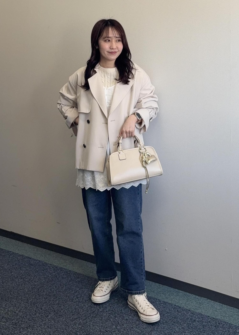 ホワイト系のニット/セーター、ベージュ系のボストンバッグ、ベージュ系のトレンチコートを着用したレディースの春コーディネートの3枚目の写真