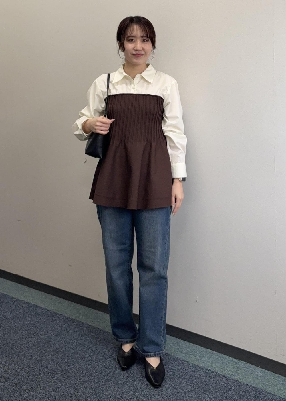 ブラック系のショルダーバッグ、ブラウン系のシャツ/ブラウス、ブルー系のデニムパンツを着用したレディースの春コーディネートの2枚目の写真