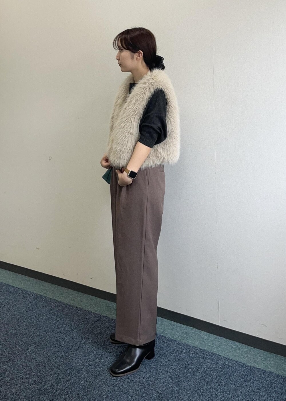 ブラウン系のショルダーバッグ、ベージュ系のスラックス、ベージュ系のベストを着用したレディースの秋コーディネートの5枚目の写真