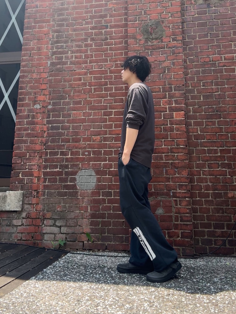 グレー系のTシャツ/カットソー、ブラック系のスウェットパンツ、グレー系のサンダルを着用したメンズの夏コーディネートの2枚目の写真