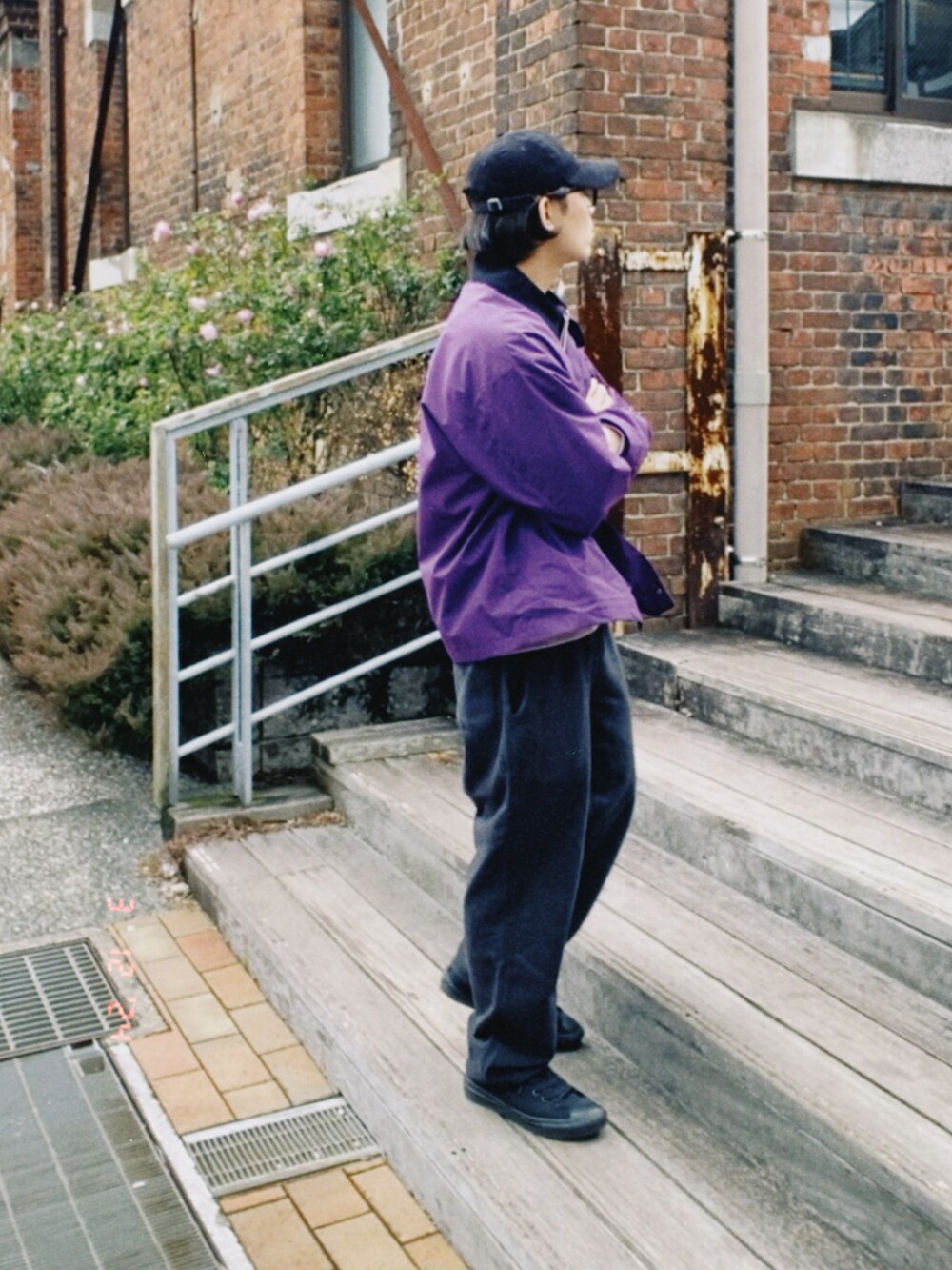 パープル系のカバーオール、パープル系のスウェット、ブラック系のスウェットパンツを着用したメンズの春コーディネートの4枚目の写真