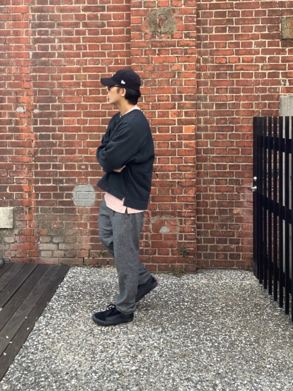 ブラック系のスウェット、ピンク系のTシャツ/カットソー、グレー系のスラックスを着用したメンズの春コーディネートの3枚目の写真