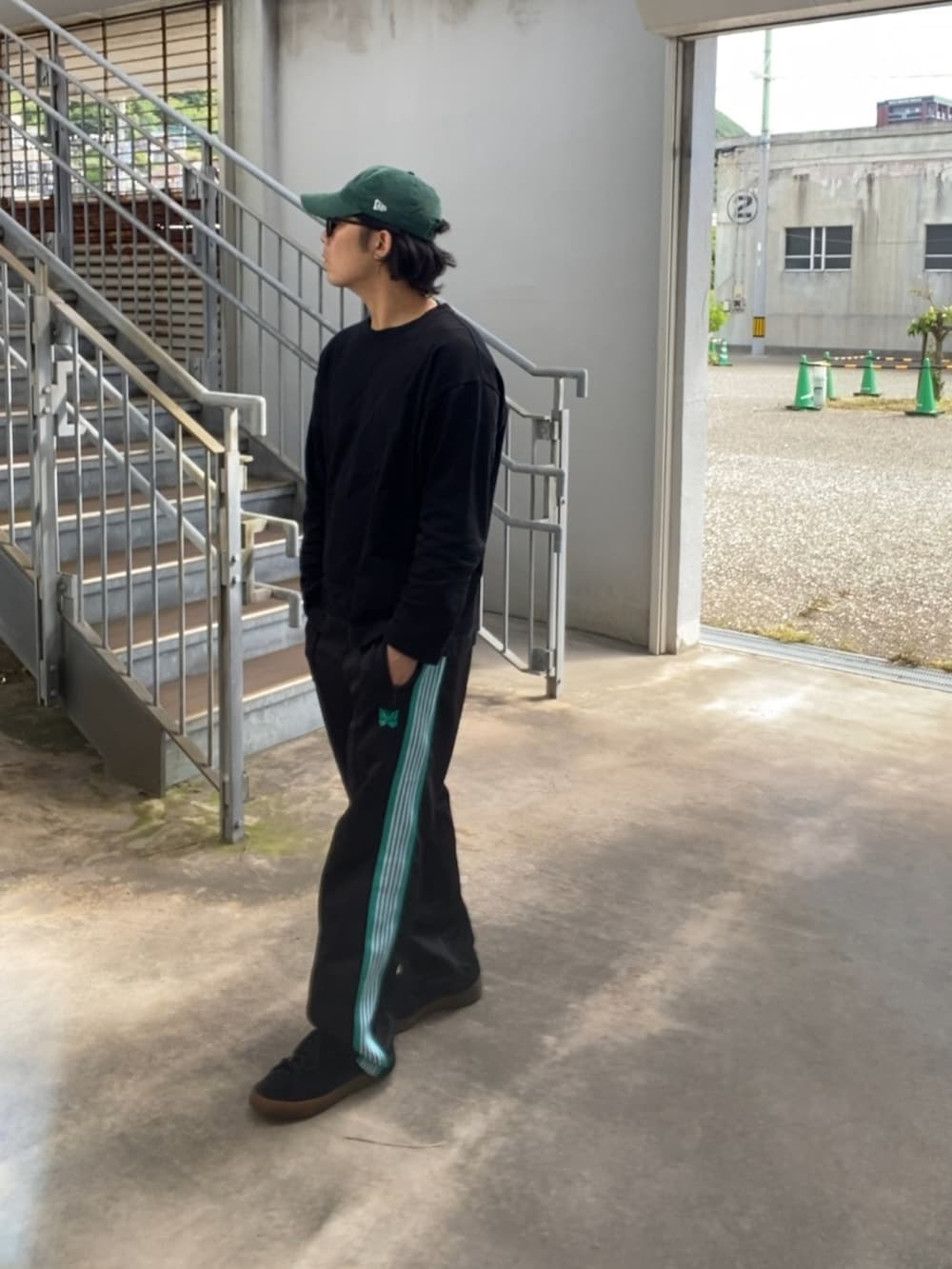 ブラック系のTシャツ/カットソー、ブラック系のその他パンツ、ブラック系のスニーカーを着用したメンズの春コーディネートの2枚目の写真