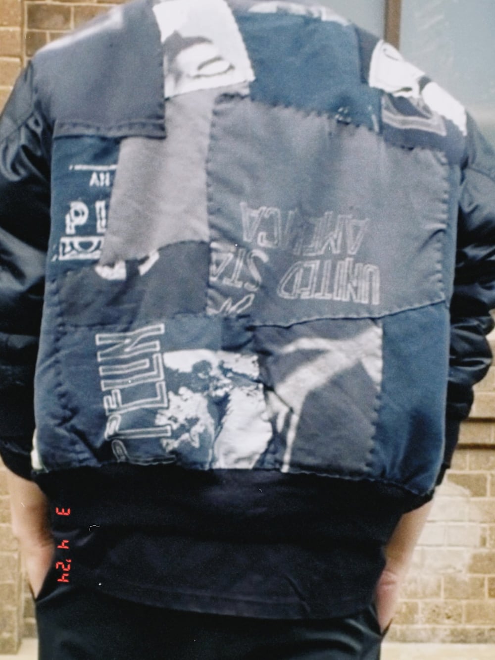 ブラック系のMA-1、ブラック系のTシャツ/カットソー、ブラック系のスラックスを着用したメンズの春コーディネートの4枚目の写真