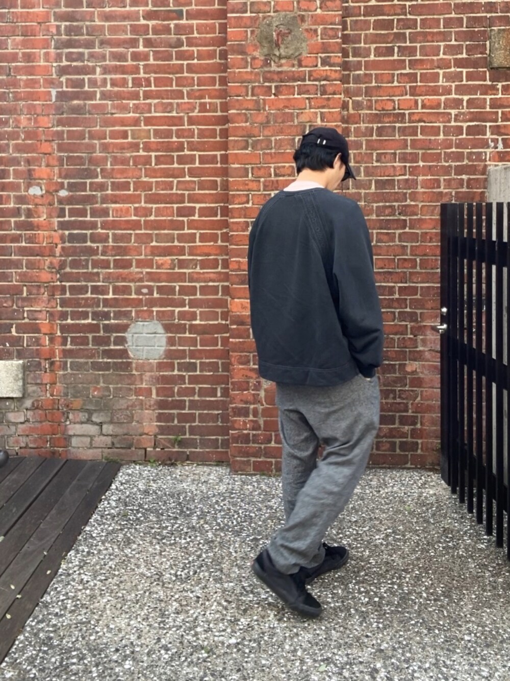 ブラック系のスウェット、ピンク系のTシャツ/カットソー、グレー系のスラックスを着用したメンズの春コーディネートの5枚目の写真