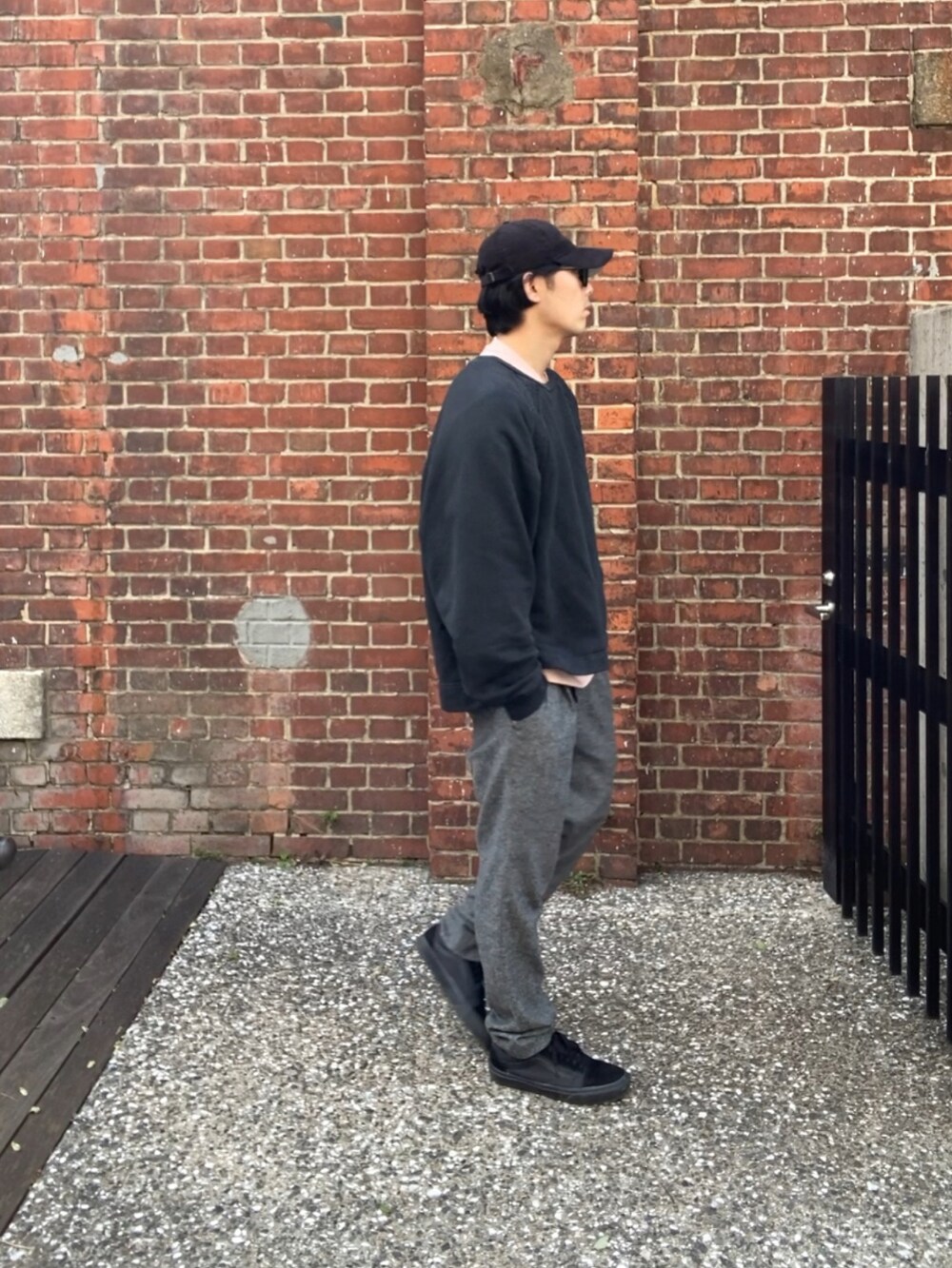 ブラック系のスウェット、ピンク系のTシャツ/カットソー、グレー系のスラックスを着用したメンズの春コーディネートの4枚目の写真