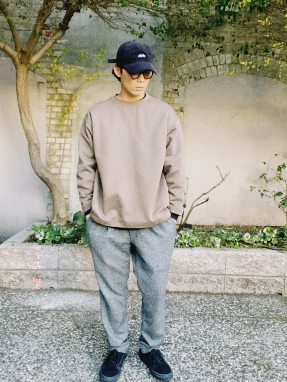 ブラウン系のトップス、グレー系のスラックス、ブラック系のスニーカーを着用したメンズの冬コーディネートの2枚目の写真