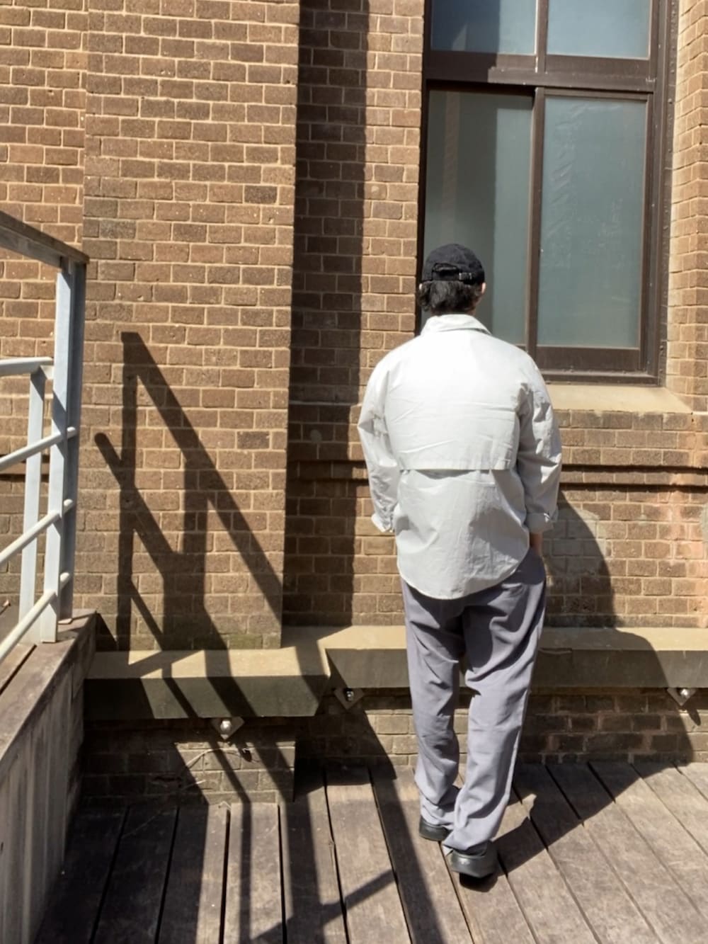 グレー系のスラックス、ブラック系のサンダル、ブラック系のタンクトップを着用したメンズの夏コーディネートの4枚目の写真