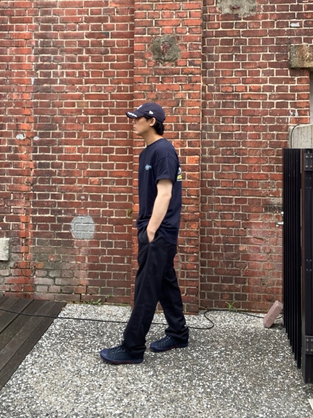 ブルー系のTシャツ/カットソー、ブラック系のスラックス、ブルー系のスニーカーを着用したメンズの夏コーディネートの2枚目の写真