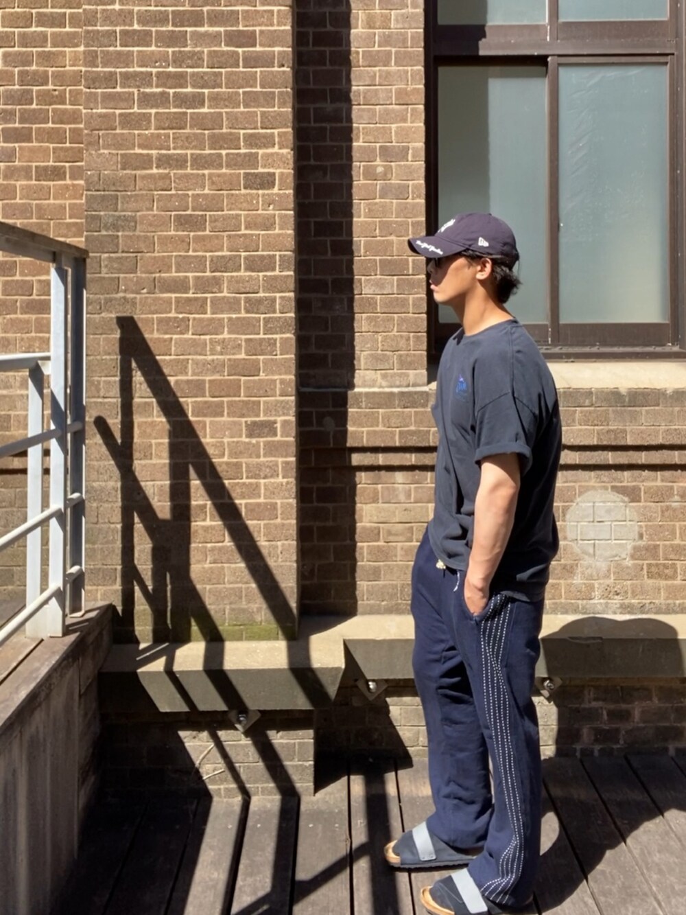 ブルー系のスウェットパンツ、ブルー系のサンダル、ブルー系のキャップを着用したメンズの夏コーディネートの2枚目の写真