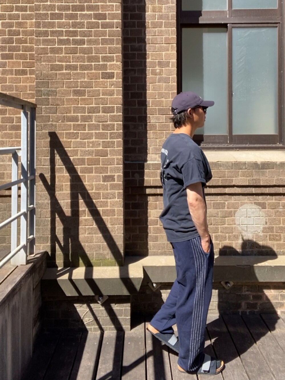 ブルー系のスウェットパンツ、ブルー系のサンダル、ブルー系のキャップを着用したメンズの夏コーディネートの3枚目の写真