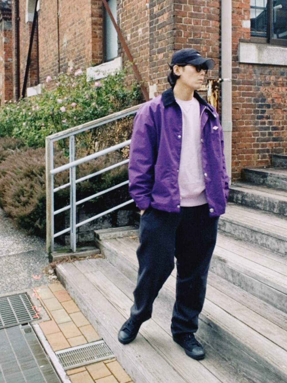 パープル系のカバーオール、パープル系のスウェット、ブラック系のスウェットパンツを着用したメンズの春コーディネートの2枚目の写真