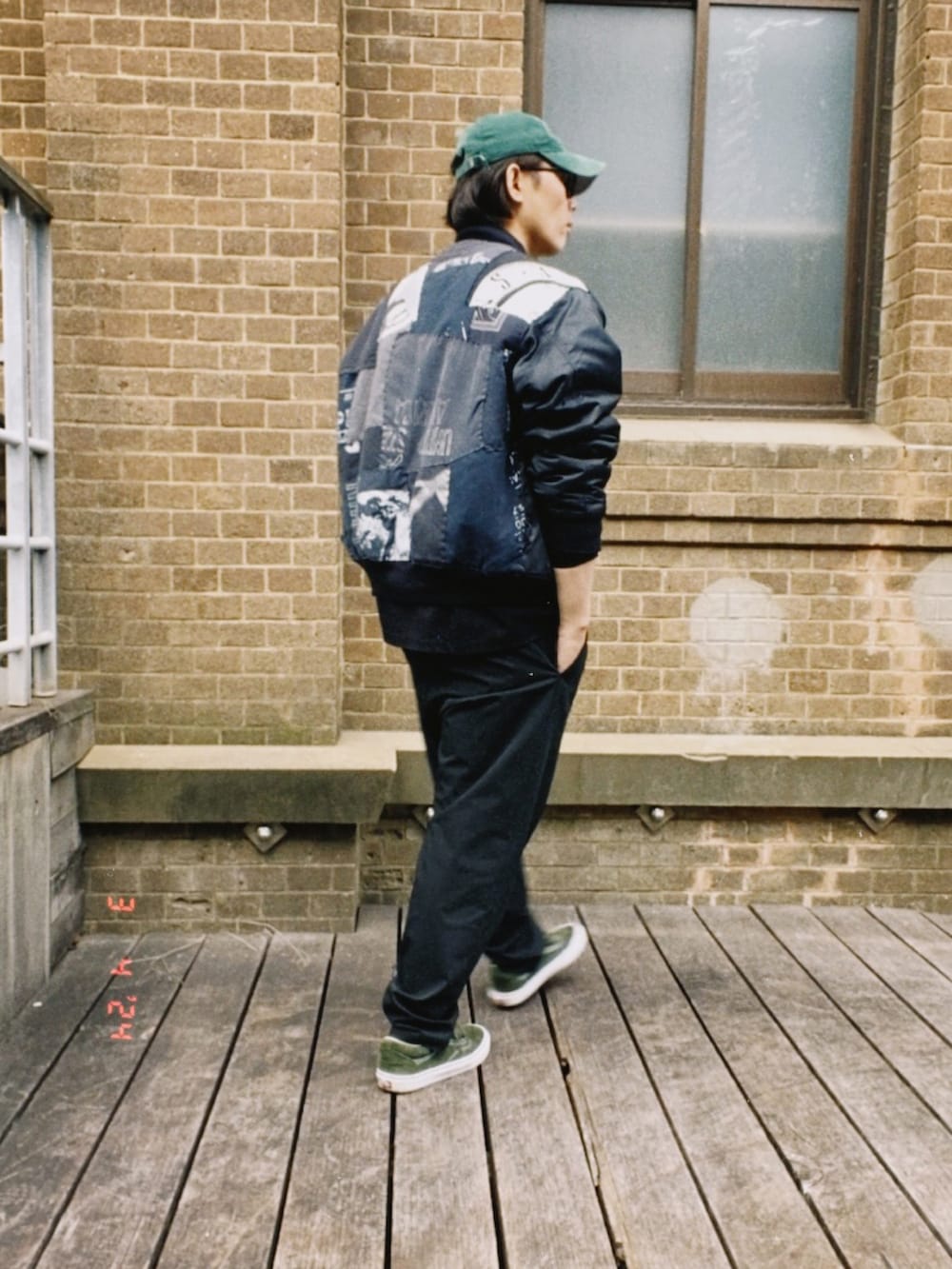 ブラック系のMA-1、ブラック系のTシャツ/カットソー、ブラック系のスラックスを着用したメンズの春コーディネートの2枚目の写真