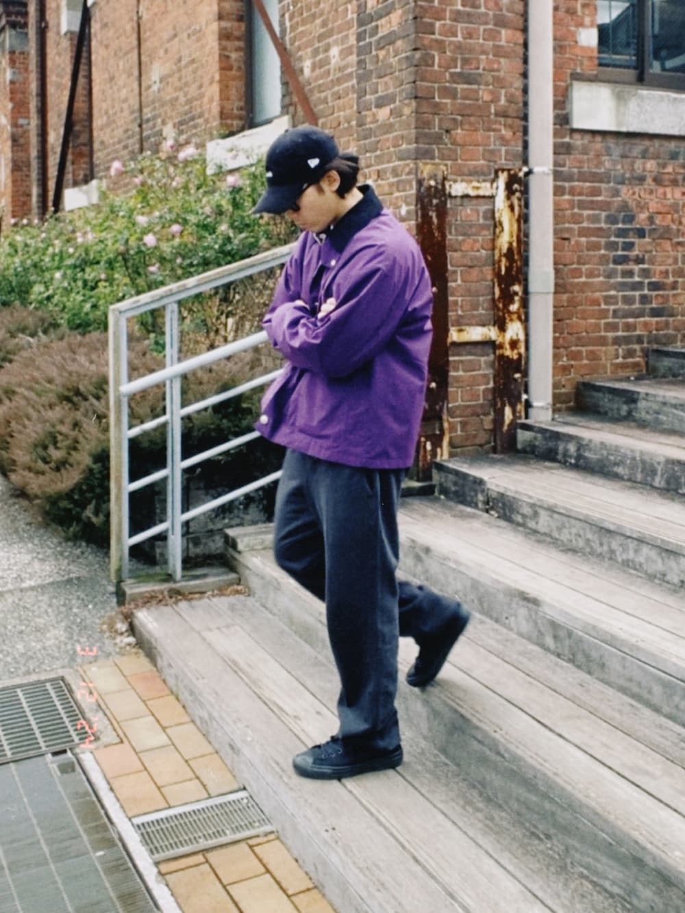 パープル系のカバーオール、パープル系のスウェット、ブラック系のスウェットパンツを着用したメンズの春コーディネートの5枚目の写真