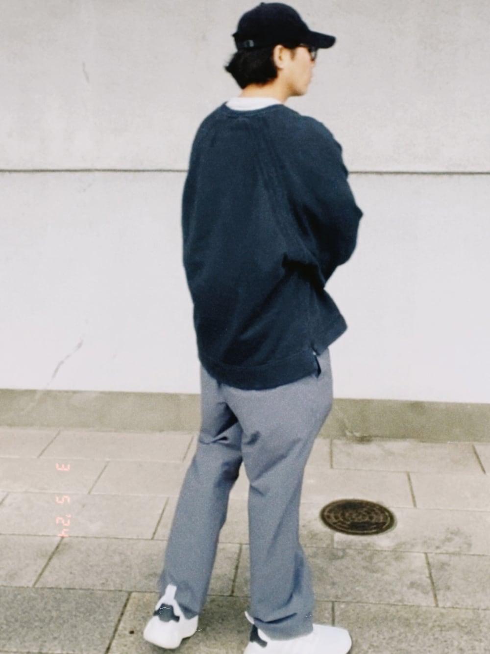 ブラック系のスウェット、グレー系のTシャツ/カットソー、グレー系のスラックスを着用したメンズの春コーディネートの4枚目の写真