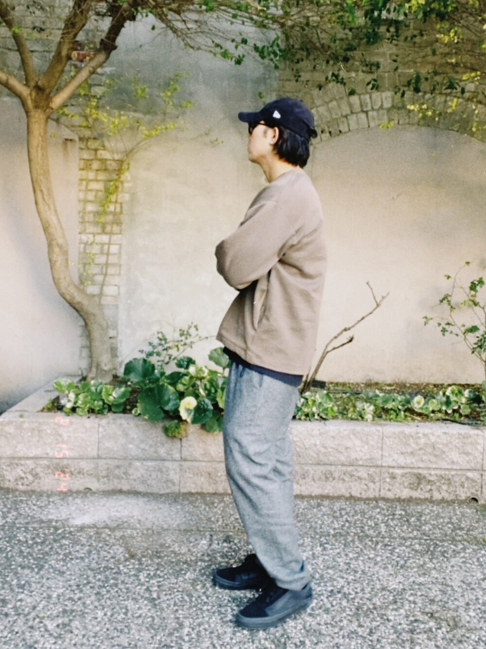 ブラウン系のトップス、グレー系のスラックス、ブラック系のスニーカーを着用したメンズの冬コーディネートの3枚目の写真