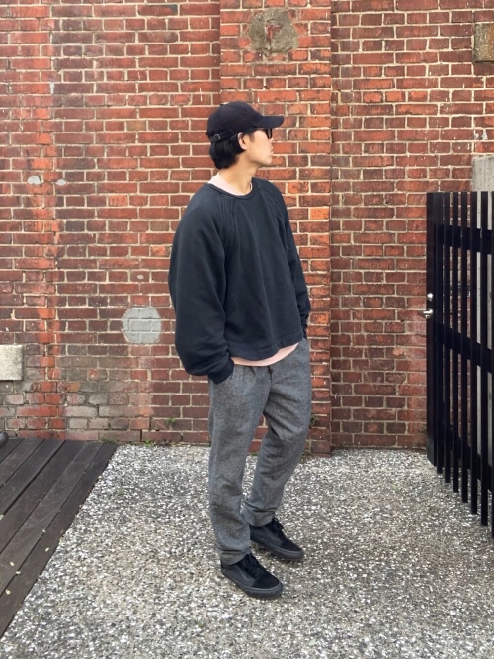 ブラック系のスウェット、ピンク系のTシャツ/カットソー、グレー系のスラックスを着用したメンズの春コーディネートの2枚目の写真