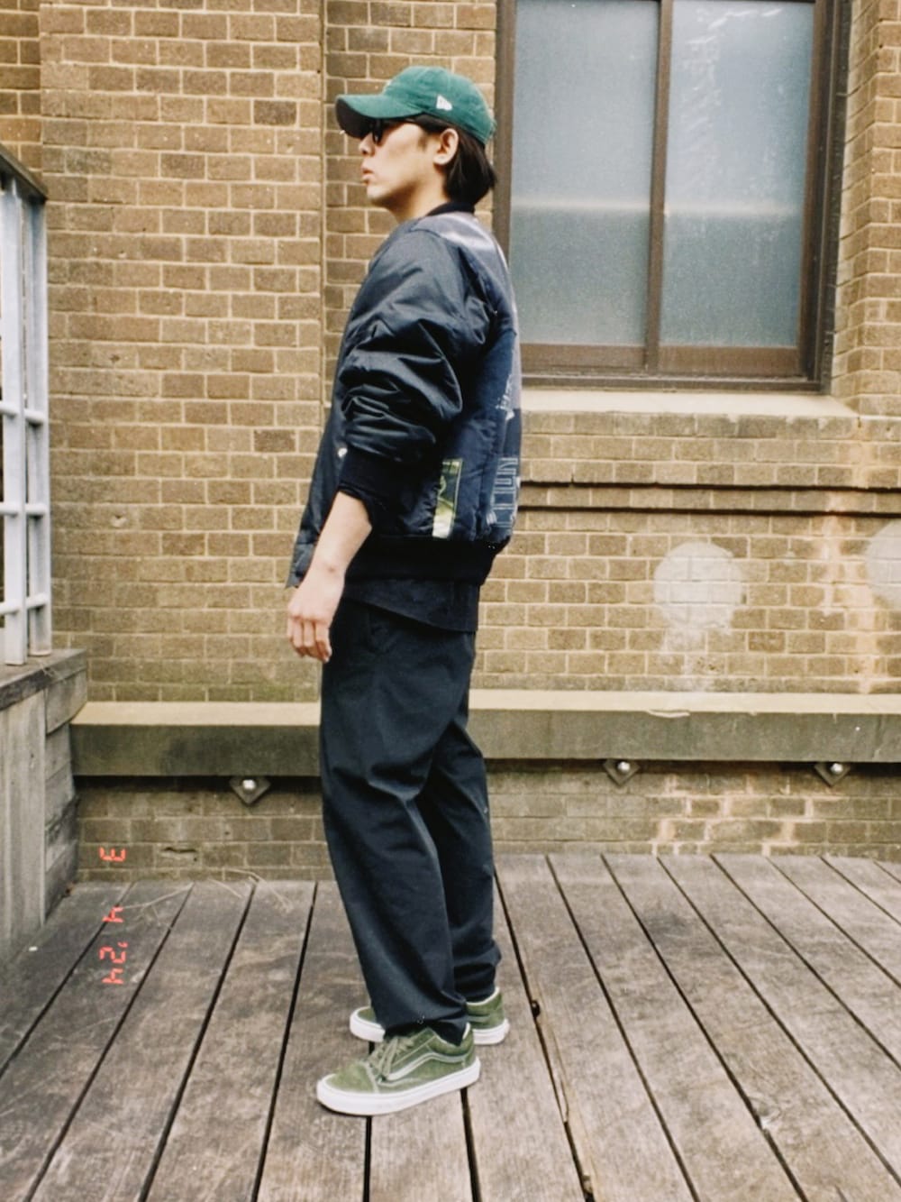 ブラック系のMA-1、ブラック系のTシャツ/カットソー、ブラック系のスラックスを着用したメンズの春コーディネートの5枚目の写真