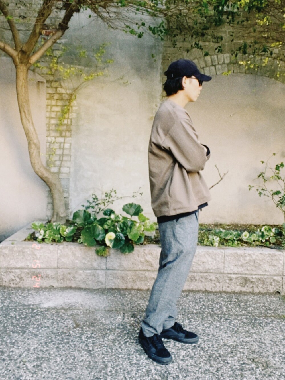 ブラウン系のトップス、グレー系のスラックス、ブラック系のスニーカーを着用したメンズの冬コーディネートの4枚目の写真