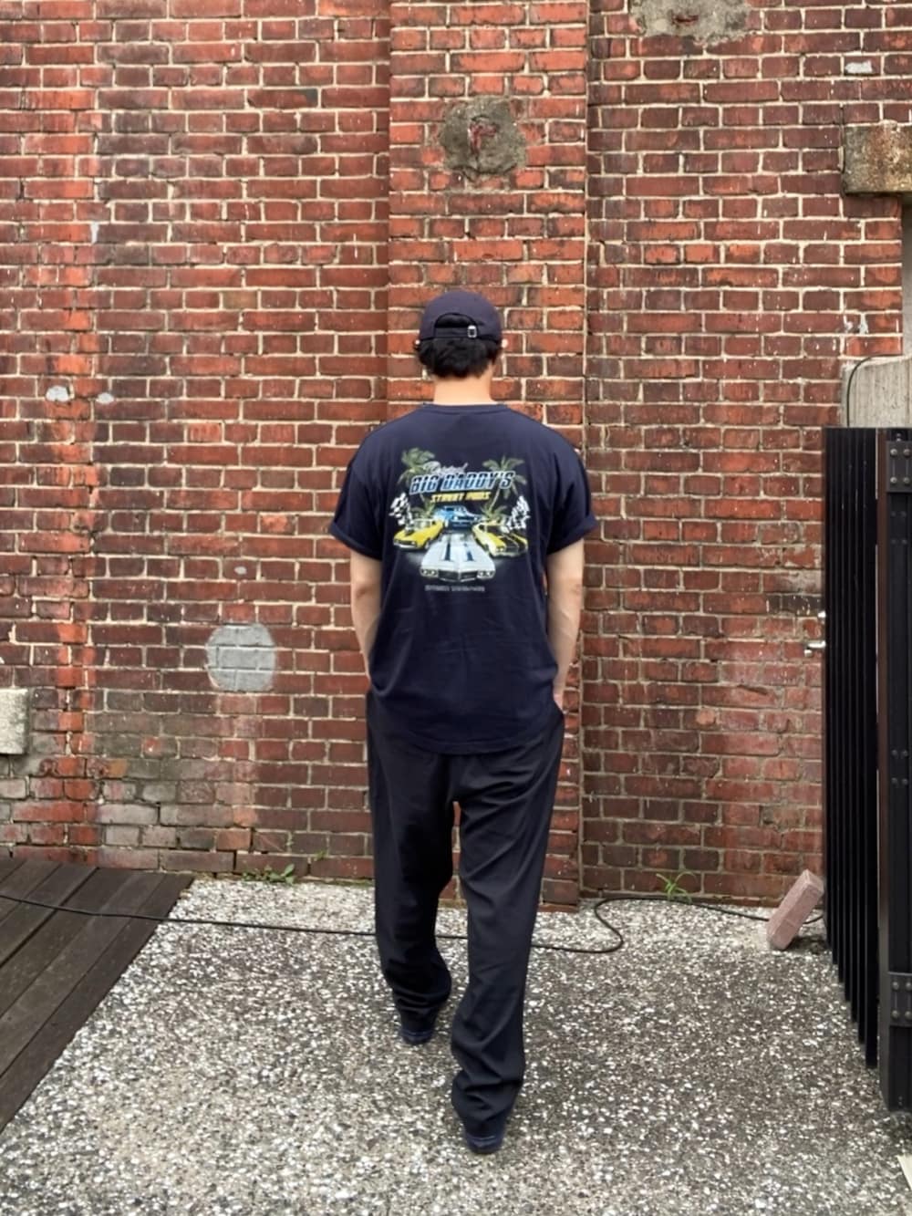 ブルー系のTシャツ/カットソー、ブラック系のスラックス、ブルー系のスニーカーを着用したメンズの夏コーディネートの4枚目の写真