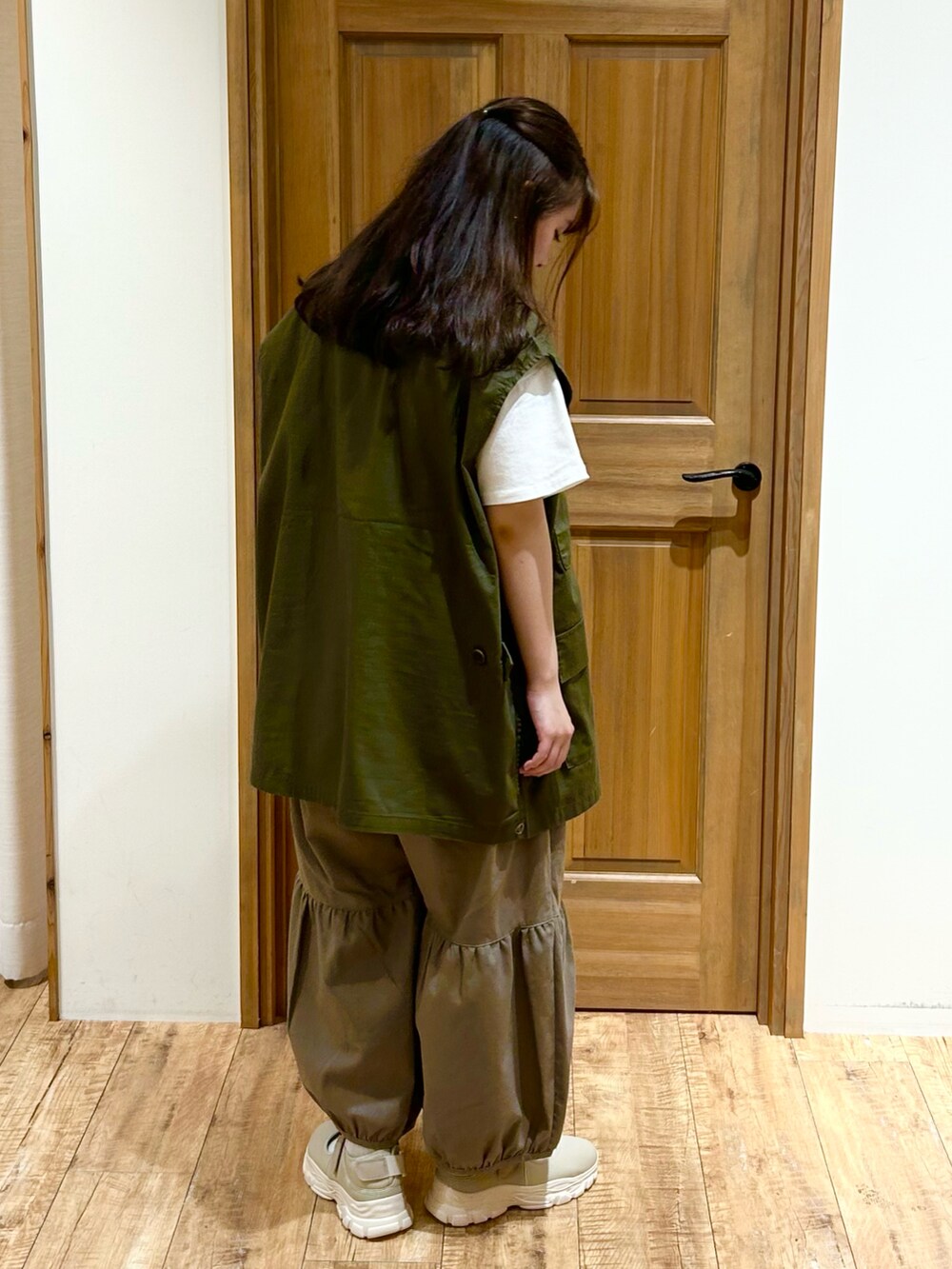 グリーン系のベスト、ホワイト系のTシャツ/カットソー、ブラウン系のその他パンツを着用したレディースの秋コーディネートの3枚目の写真