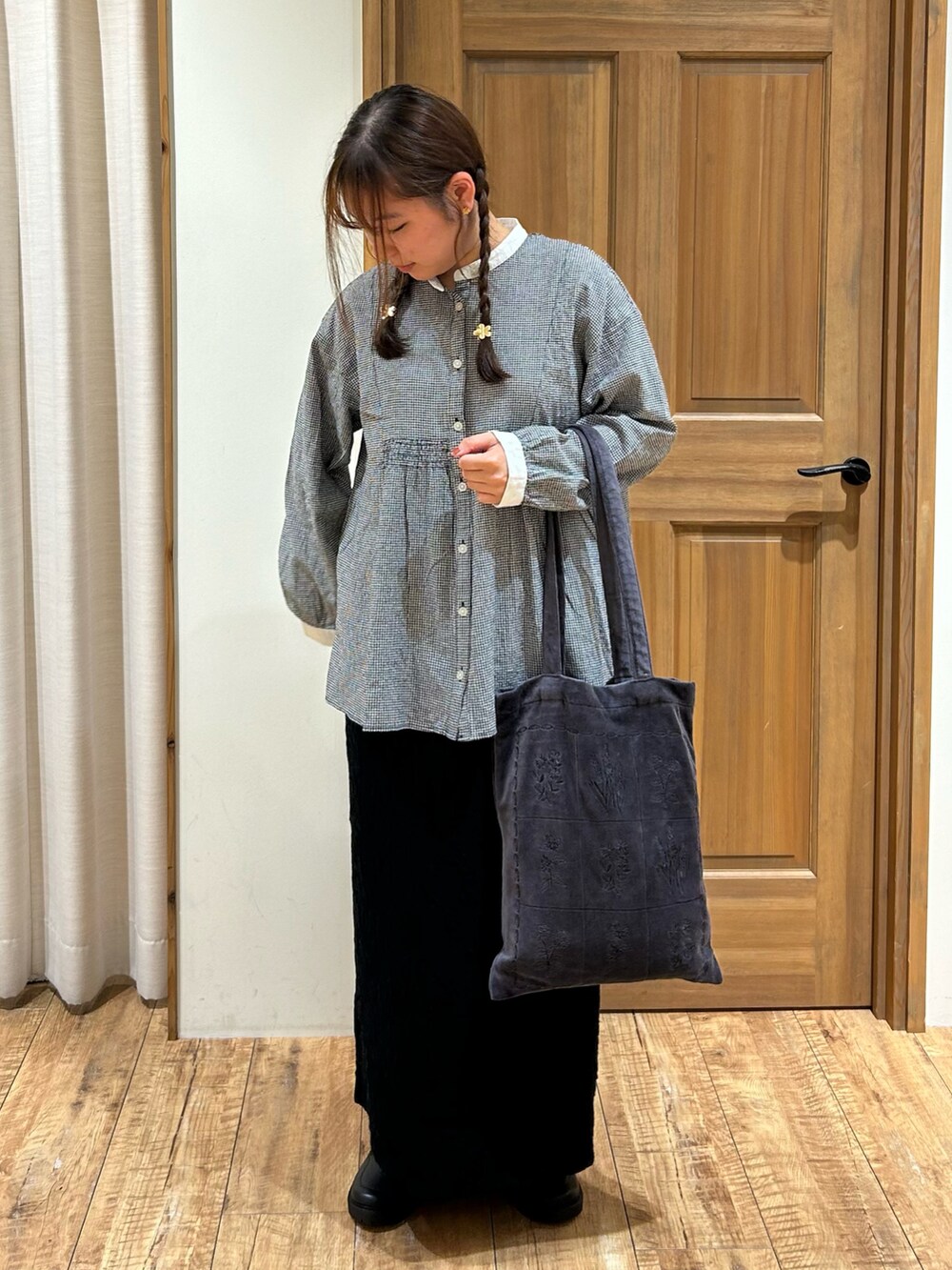 ブラック系のシャツ/ブラウス、ブラック系のスカート、グレー系のハンドバッグを着用したレディースの秋コーディネートの2枚目の写真