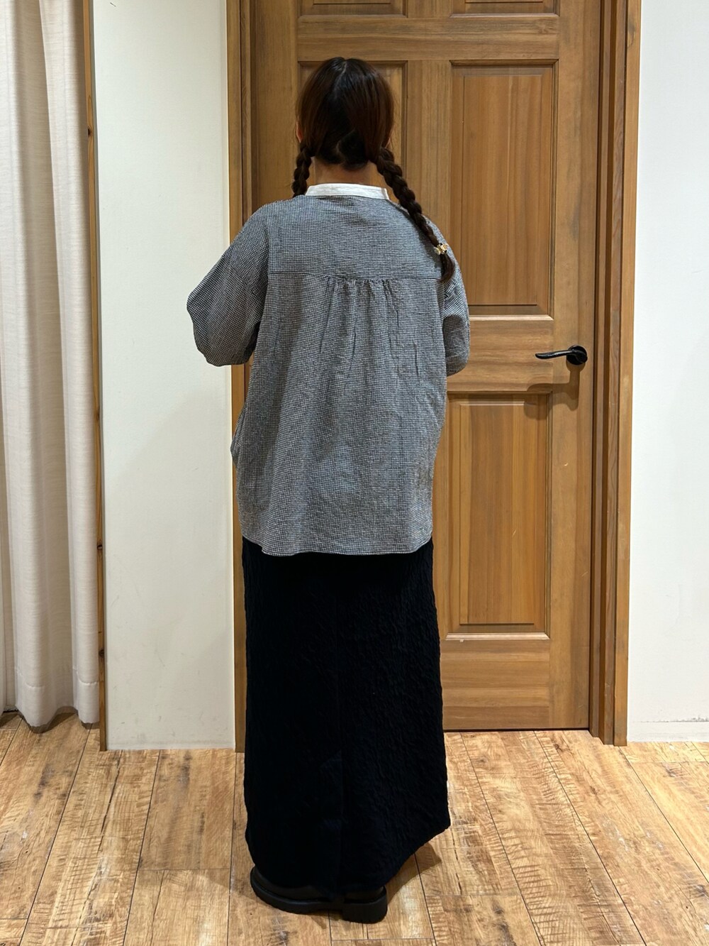 ブラック系のシャツ/ブラウス、ブラック系のスカート、グレー系のハンドバッグを着用したレディースの秋コーディネートの5枚目の写真