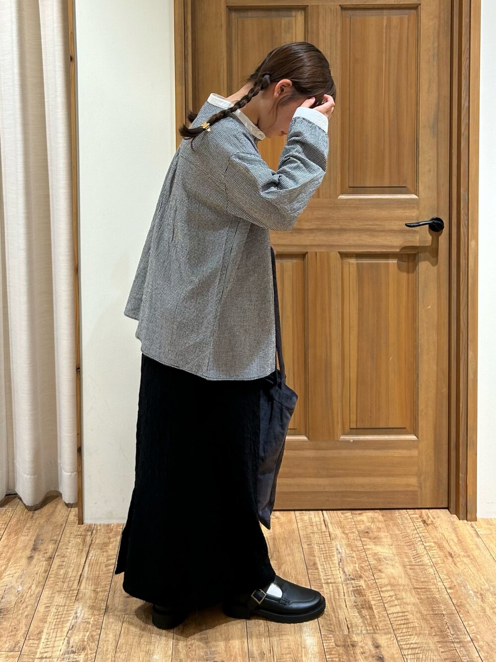 ブラック系のシャツ/ブラウス、ブラック系のスカート、グレー系のハンドバッグを着用したレディースの秋コーディネートの3枚目の写真