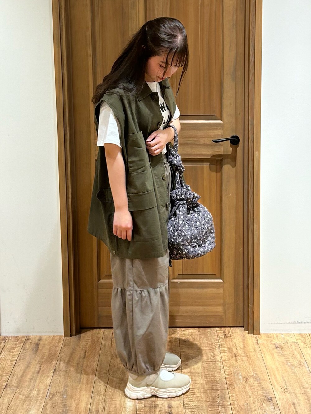 グリーン系のベスト、ホワイト系のTシャツ/カットソー、ブラウン系のその他パンツを着用したレディースの秋コーディネートの2枚目の写真