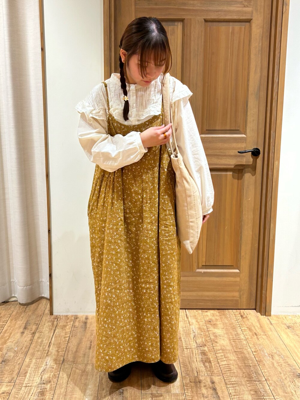 ホワイト系のシャツ/ブラウス、イエロー系のワンピース、ベージュ系のハンドバッグを着用したレディースの秋コーディネートの2枚目の写真